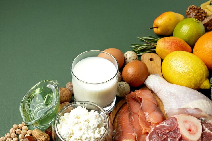 Pahar cu lapte și brânză proaspătă alături de alimente bogate în proteine și nutrienți, ilustrând rolul laptelui și produselor lactate într-o alimentație echilibrată.