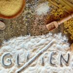 Imagine ilustrativă despre gluten, cu făină, pâine, paste, orez și cereale integrale, utilizată în articole despre alimentație și intoleranța la gluten.