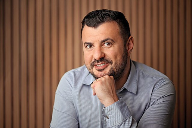 Portretul lui Daniel Donici, cofondator Artesana, fotografiat pe fundal cu lamele din lemn.