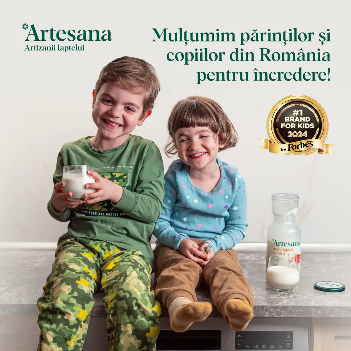 Doi copii in bucatarie cu un pahar d de lapte minim proceasat de la Artesana in mana