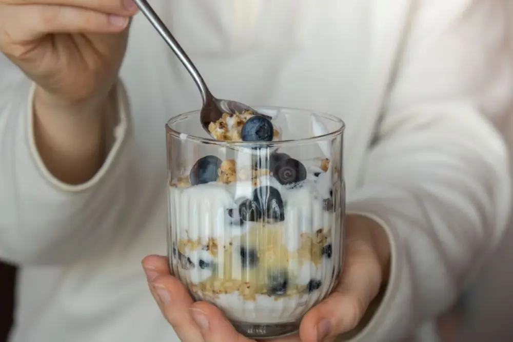 Un borcan de iaurt delicios cu afine si cereale musli, un mic dejun sanatos pentru familie de la artizanii laptelui Artesana