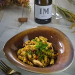 O salata de paste cu piept de pui si o sticla de vin Chardonay