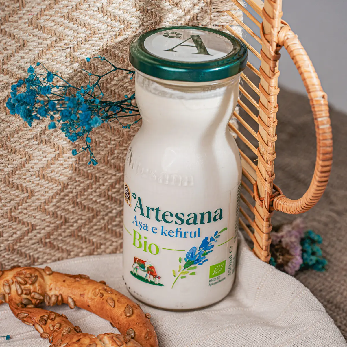 O sticla de kefir din lapte ecologic (bio) langa un covrig proaspat cu seminte