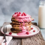Farfurie cu clătite pufoase și topping și o sticlă cu kefir 