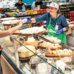 Vitrina Atelier Artesana în Carrefour Băneasa, cu personalul oferind mostre de brânză artizanală vizitatorilor.