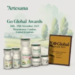 Imagine promoțională Artesana pentru Go Global Awards 2025, prezentată cu o selecție de produse lactate artizanale: iaurt, kefir, lapte integral, smântână și brânză cremoasă, toate în ambalajele albe, recognoscibile, cu design minimalist și elemente ilustrate naturale. În dreapta se află trofeul “Dairy Product Exporter of the Year – Go Global Awards 2025”, acordat brandului Artesana. Fundalul prezintă o ilustrație idilică de peisaj rural, sugerând origine locală, prospețime și producție autentică. Textul anunță participarea Artesana la evenimentul Go Global Awards, 18–19 noiembrie 2025, Westminster, Londra, UK.