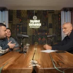 Alina Donici, Daniel Donici si Damian Draghici la o discuție înregistrată într-un studio modern de podcast, așezate la o masă lungă din lemn masiv, cu microfoane profesionale în față și decor cu panouri textile în fundal.