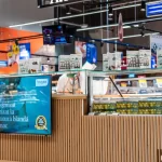 Stand Atelier Artesana în Carrefour Baneasa supermarket, cu produse lactate artizanale expuse și design modern din lemn natural.