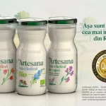 Trei sticle de kefir Artesana – integral, Bio și de capră – prezentate pe fundal natural, alături de medalia Qudal 2025/2026 pentru cea mai înaltă calitate din România.