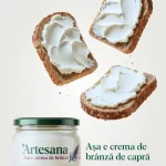 Borcan de cremă de brânză de capră Artesana, cu felii de pâine integrală unse cu cremă fină, prezentate pe fundal deschis.