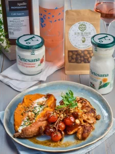 Pulpe de pui marinate în sana Artesana și rumenite la cuptor, servite cu cartof dulce copt, roșii cherry caramelizate și alune de pădure, alături de smântână 35% grăsime și sana Artesana, ingrediente naturale pentru o rețetă savuroasă.