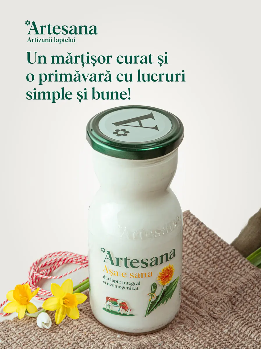 Sticlă de lapte Artesana „Așa e sana”, din lapte integral și neomogenizat, cu capac verde, așezată pe material textil, alături de flori galbene de primăvară și șnur de mărțișor, mesaj „Un mărțișor curat și o primăvară cu lucruri simple și bune”.
