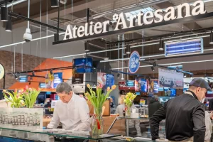 Atelier Artesana în supermarket – stand de degustare cu produse lactate artizanale Artesana și decor cu flori de primăvară, în cadrul unui eveniment dedicat zilei de 8 Martie.