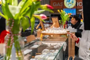 Degustare de brânzeturi artizanale Artesana din lapte de vacă și capră, prezentate pe standul Atelier Artesana într-un supermarket, în cadrul unui eveniment special de 8 Martie.