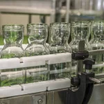 Sticle și borcane de sticlă Artesana pe linia de îmbuteliere în fabrica de lactate pentru lapte și iaurt artizanal