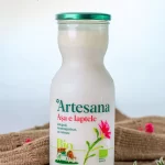 Sticlă de lapte bio Artesana integral, neomogenizat, cu caimac, ambalat în borcan de sticlă, pe fundal rustic din pânză, produs natural artizanal din România