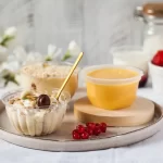 Deserturi pe bază de lactate – iaurt cremos cu topping de nuci și fructe, budincă și piure de fructe, servite elegant pe tavă, concept de gustare sănătoasă și naturală