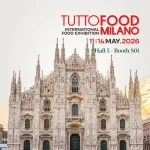 Vizual promoțional Artesana care anunță participarea la TuttoFood Milano 2026, expoziția internațională dedicată industriei alimentare, desfășurată la Milano în perioada 11–14 mai 2026. Imaginea include logo-ul Artesana și sloganul „Artizanii laptelui” în colțul din stânga sus, logo-ul TuttoFood Milano în roșu și negru în partea superioară centrală și informațiile despre locație „Hala 5 – Stand S01”. Fundalul este dominat de o imagine frontală a celebrului Dom din Milano (Duomo di Milano), surprins la răsărit, într-o lumină caldă și elegantă.