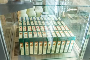Cutii cu brânzeturi maturate Artesana expuse într-o vitrină frigorifică la târgul Tutto Food Milano 2026, alături de sticle și borcane cu produse lactate artizanale.