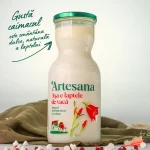 Sticlă de lapte de vacă Artesana integral, neomogenizat, cu caimac natural la suprafață, ambalată în sticlă, alături de mesajul „Gustă caimacul, este smântâna dulce, naturală a laptelui”.