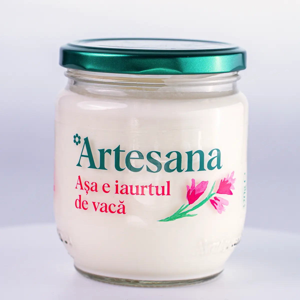 Borcan de iaurt de vacă Artesana 160 g, obținut din lapte integral românesc, neomogenizat și pasteurizat la temperatură blândă, ambalat în borcan de sticlă cu capac verde.
