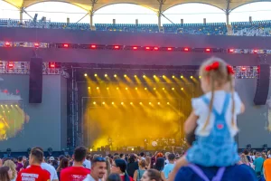 Concert la SAGA Festival 2026 pe Arena Națională, cu public numeros și o fetiță privind scena din mulțime.