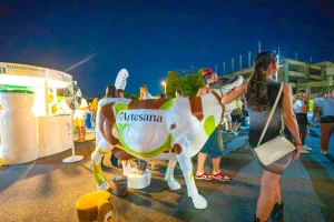 Vizitatoare fotografiate alături de vaca Musana la standul Artesana de la SAGA Festival 2026.