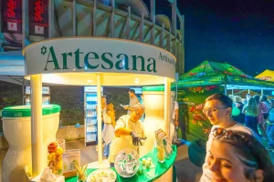 Participanți la degustare în standul Artesana de la SAGA Festival 2026, lângă instalația în formă de sticlă de lapte.
