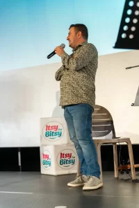 Daniel Donici, fondator Artesana, vorbește la microfon pe scena evenimentului „Tați care iubesc” din București.