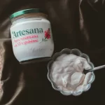 Smântâna Artesana este lângă un bol cu smântână care are o lingură în el.
